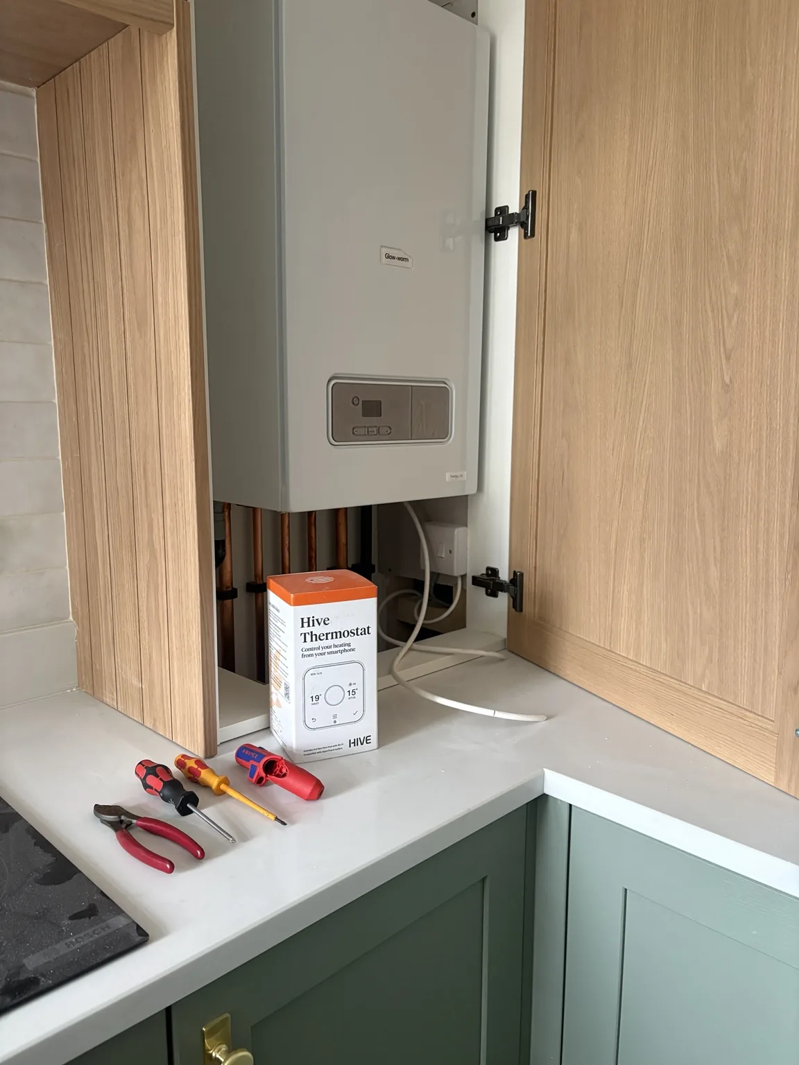 Glow-worm boiler installed neatly in a kitchen cupboard with Hive smart thermostat by Medway Heating & Plumbing